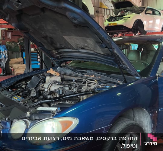 רכב במוסך עם מכסה מנוע פתוח, רכבים נוספים ברקע
